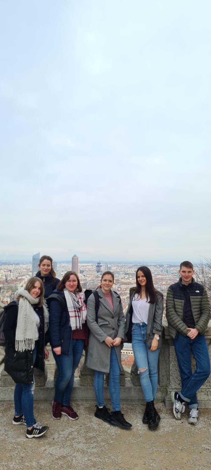 Studenten stehen auf einer Aussichtsplattform mit der Stadt Lyon im Hintergrund