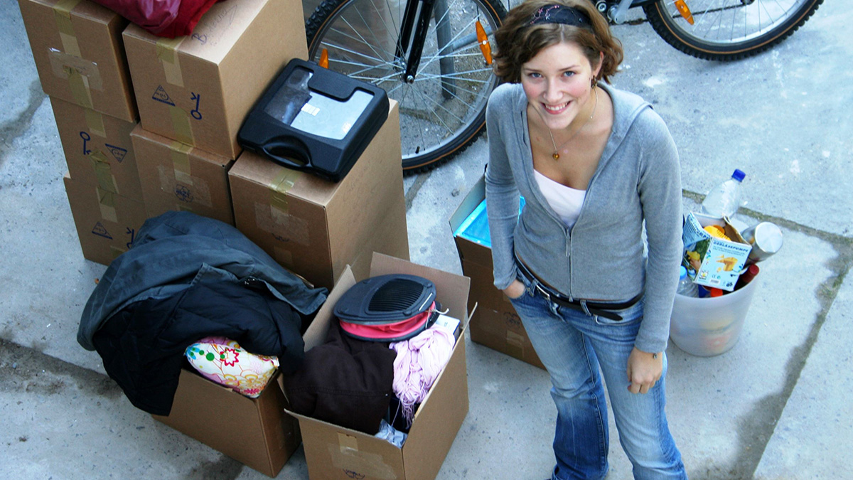Photo: Young woman standing in front of moving boxes