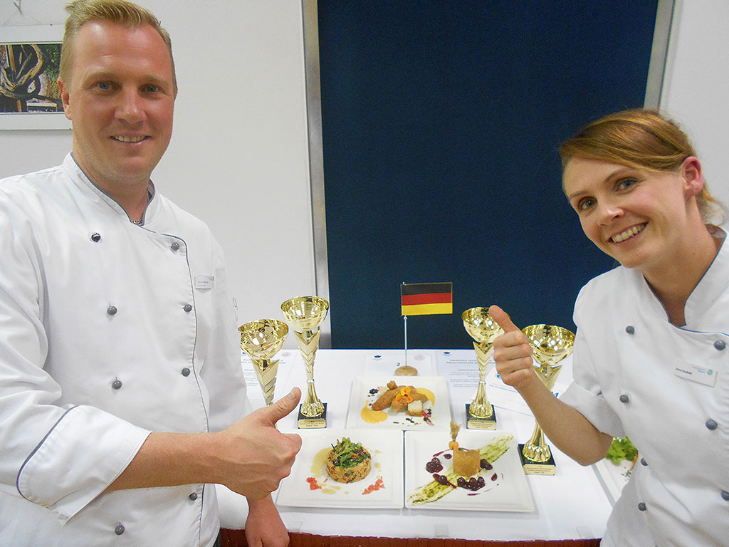 Foto des Siegerteams bestehend aus Anne Haubold und Enrico Möckel mit ihren Gerichten im Hintergrund
