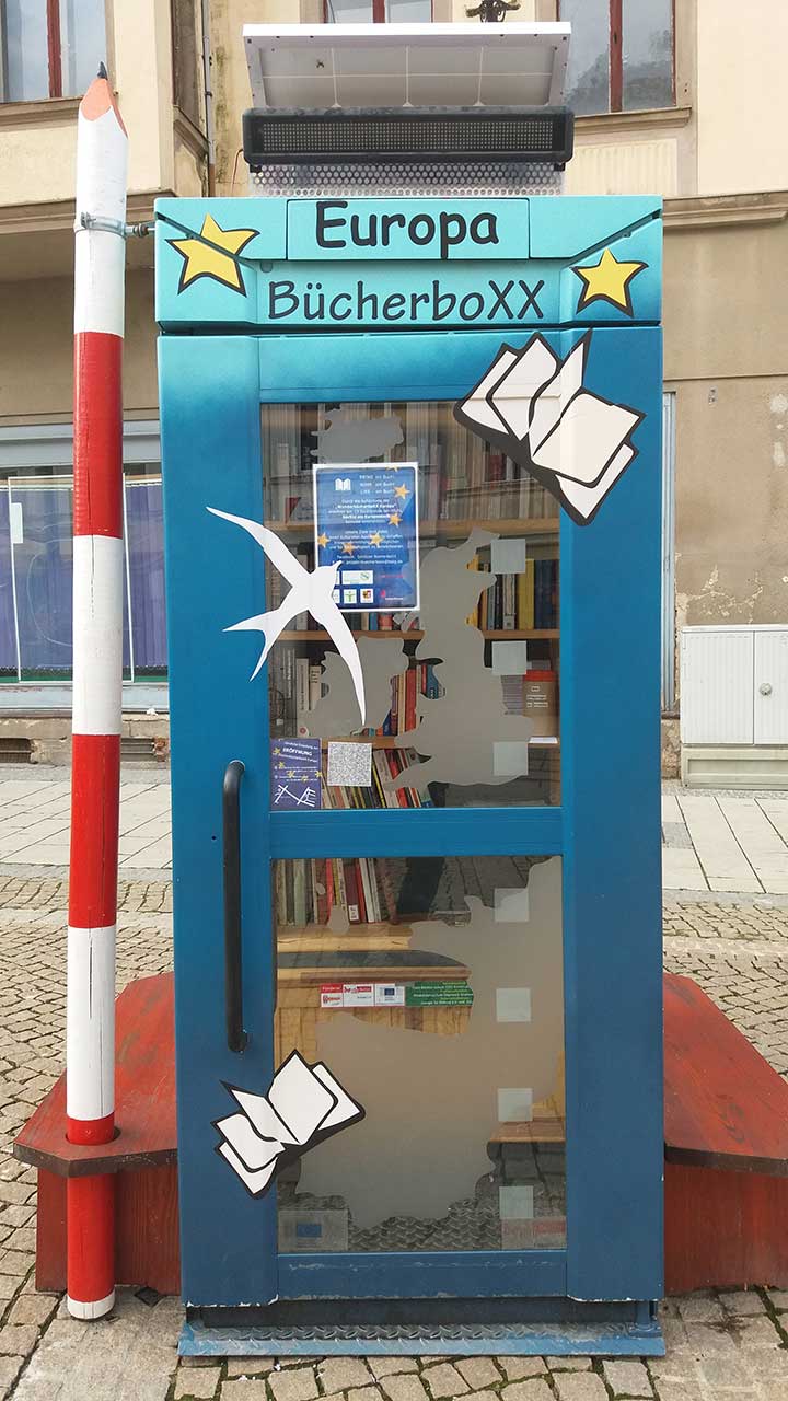 Das Foto zeigt die nachhaltige BücherboXX mit dem Thema Europa von außen. Auf ihrer Tür sind Sterne, Bücher und ein Vogel abgebildet.