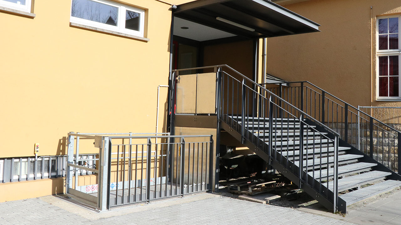 Image of the stairs at the rear entrance of the tusculum with the lift on the left side of the stairs